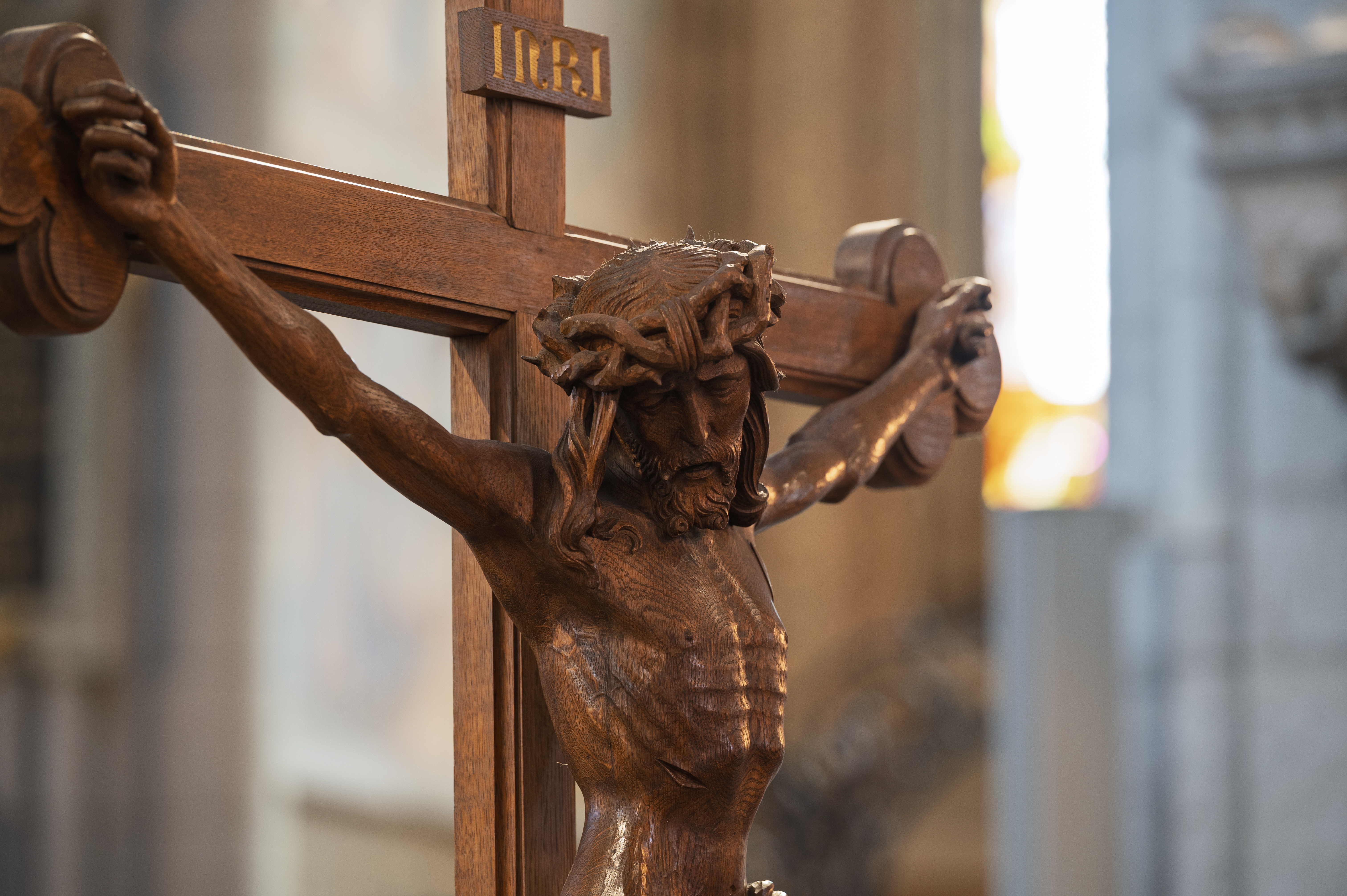 Närbild på ett krucifix i mörkt trä.