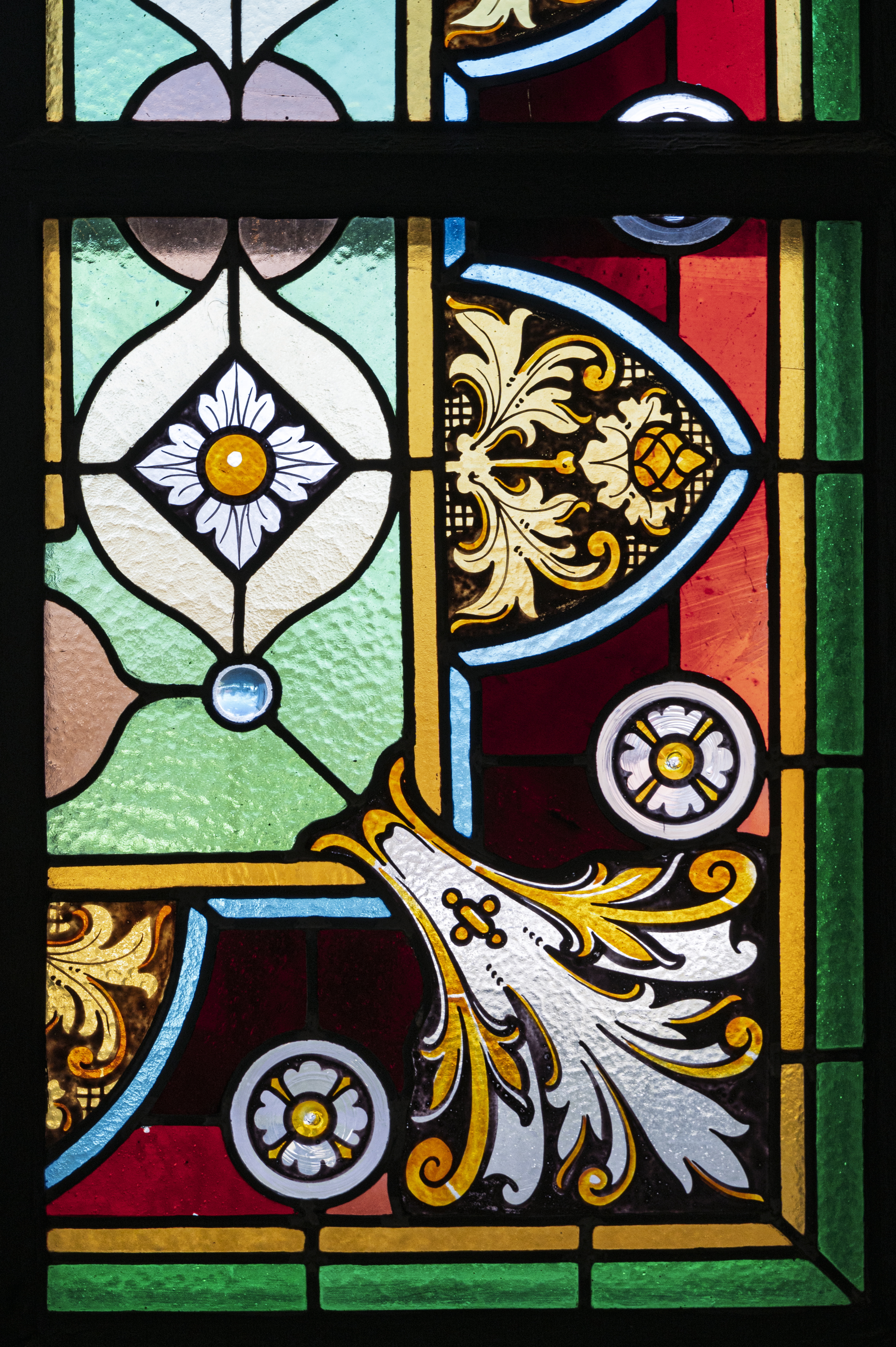Närbild på ett kyrkfönster med en glasmålning.