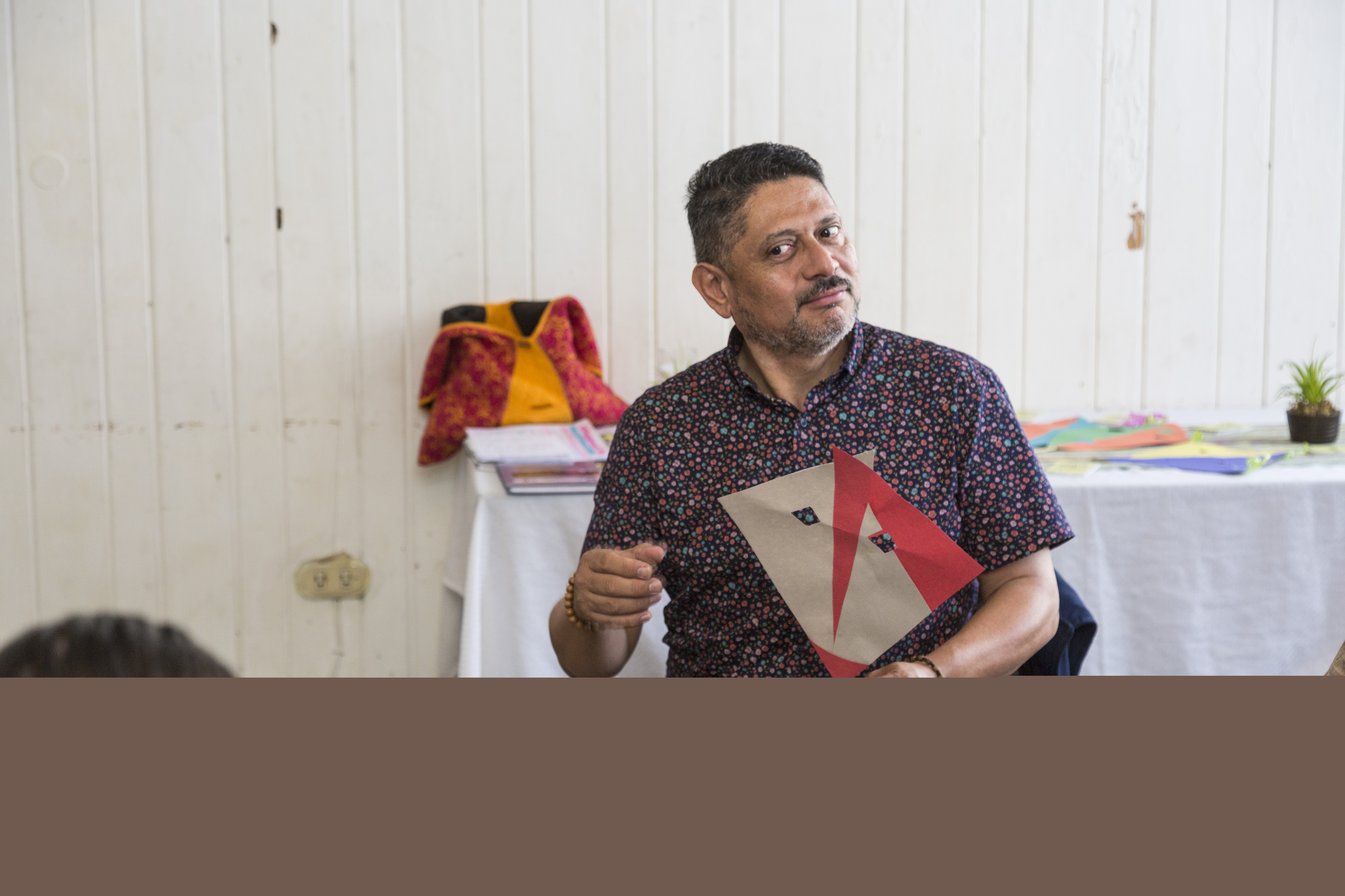 En man med en mask i handen, de övar rollspel. 