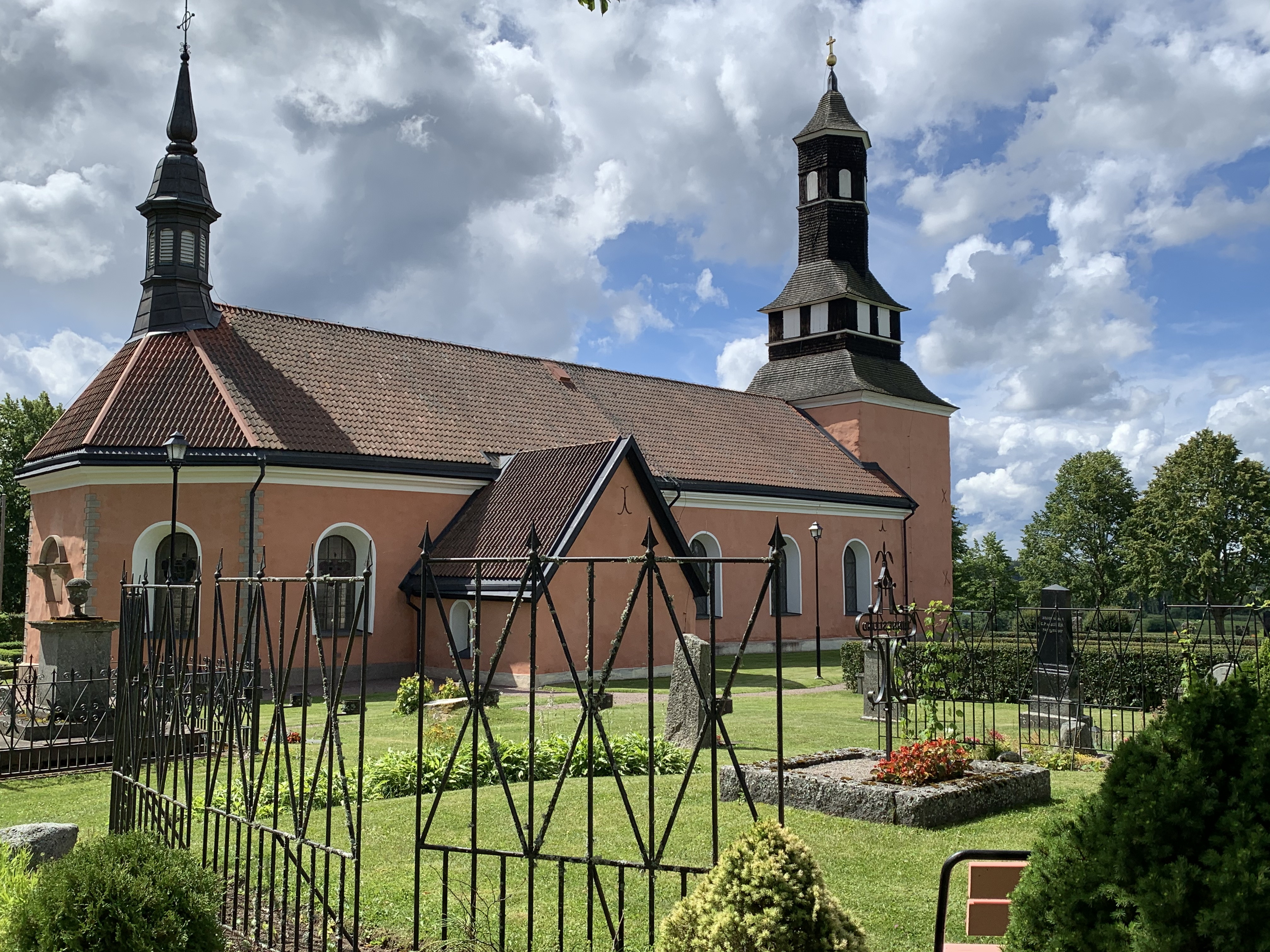 Ekeby rosa kyrka med kyrkogården i förgrunden