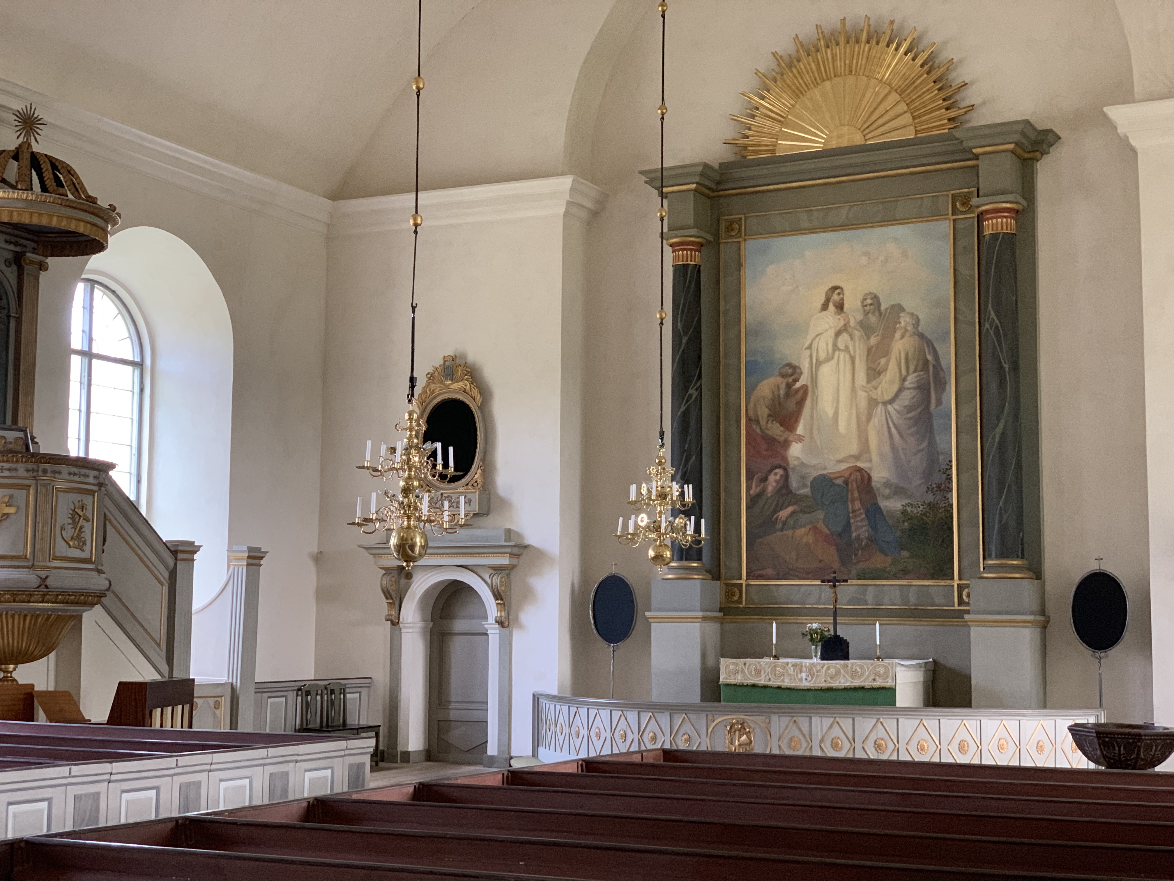 Interiörbild Vallerstads kyrka med altartavlan och del av predikstol.