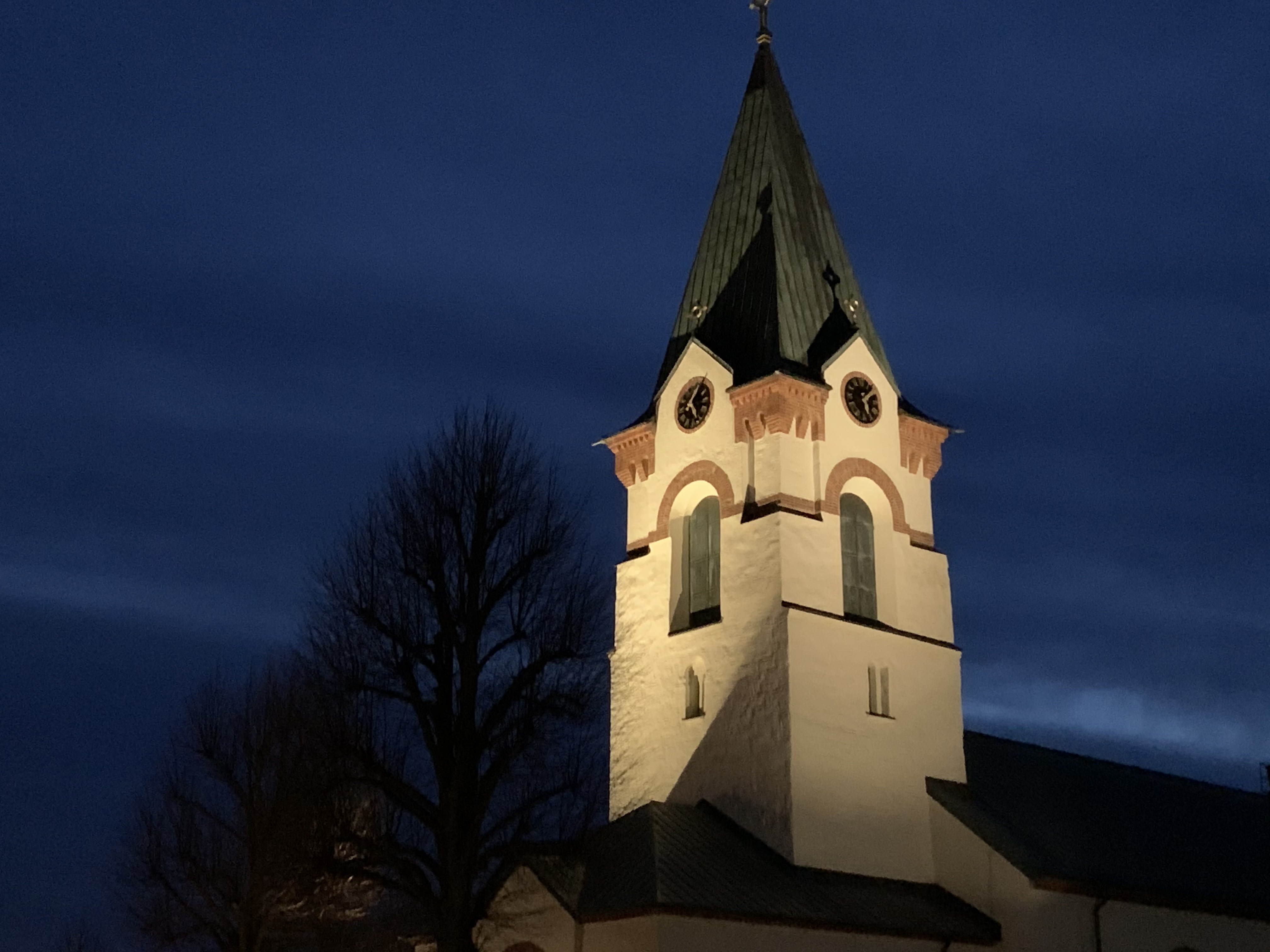 Ödeshögs kyrkas torn upplyst i natten.