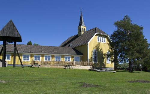 Bilden visar Ersmarks kyrka i Ersmark/Kågedalen. Kyrkan är byggd i trä och gulmålad.  Bilden är tagen på sommarhalvåret. 