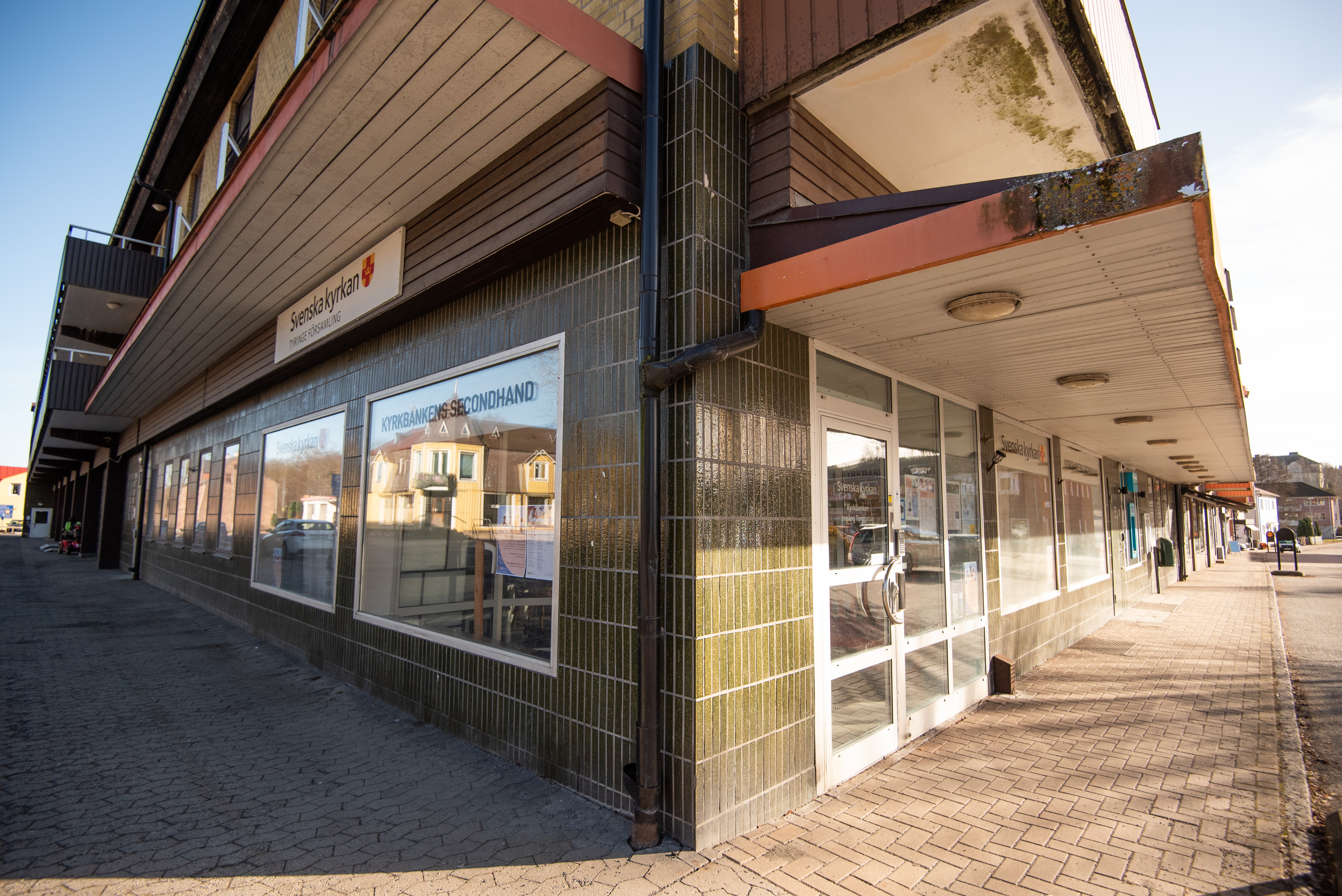 En gatuhörna med trottoar i två riktningar. Här på hörnan finns en ingång till en butik.
