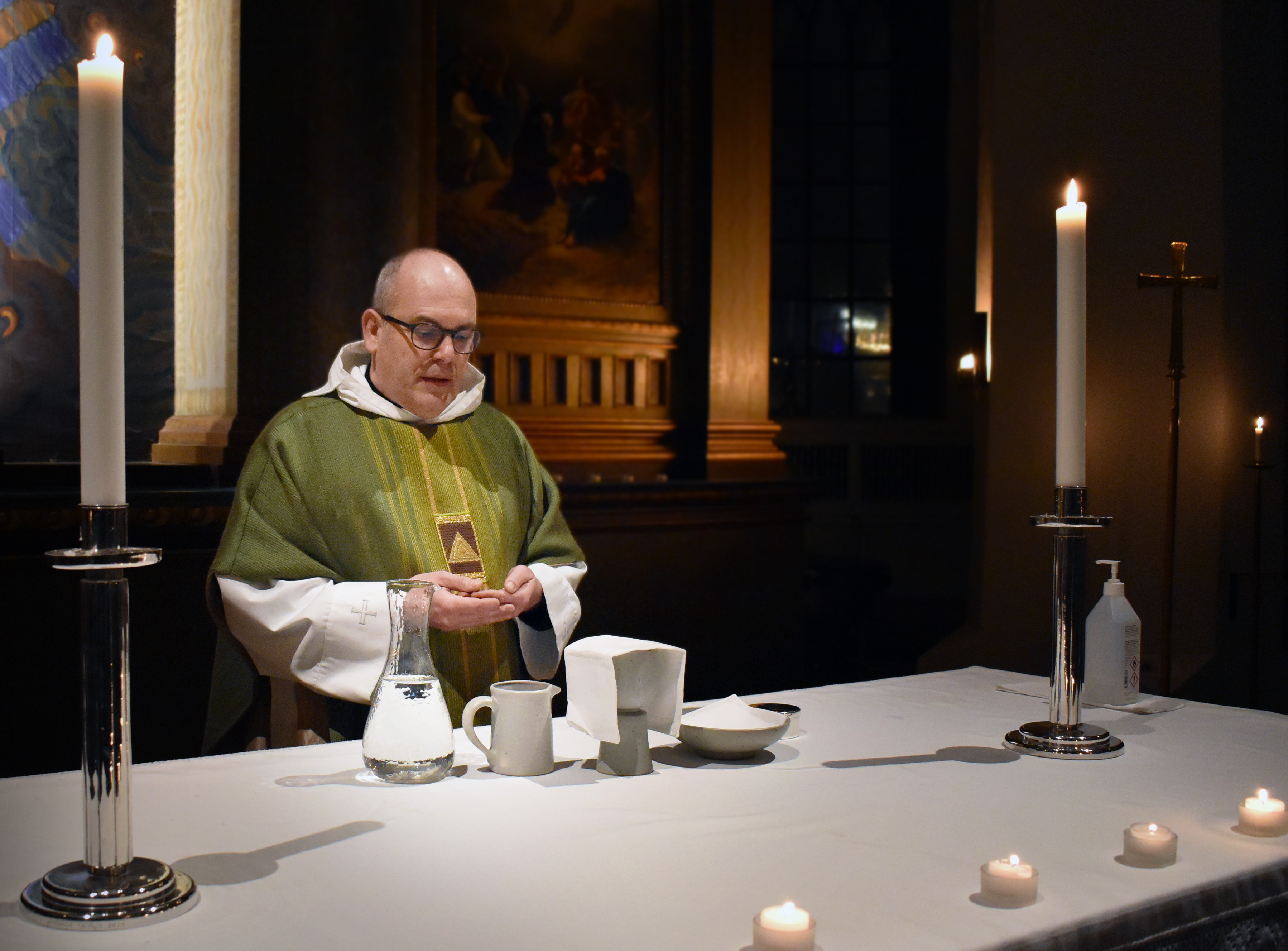 Präst vid altare i kyrka under nattvard.