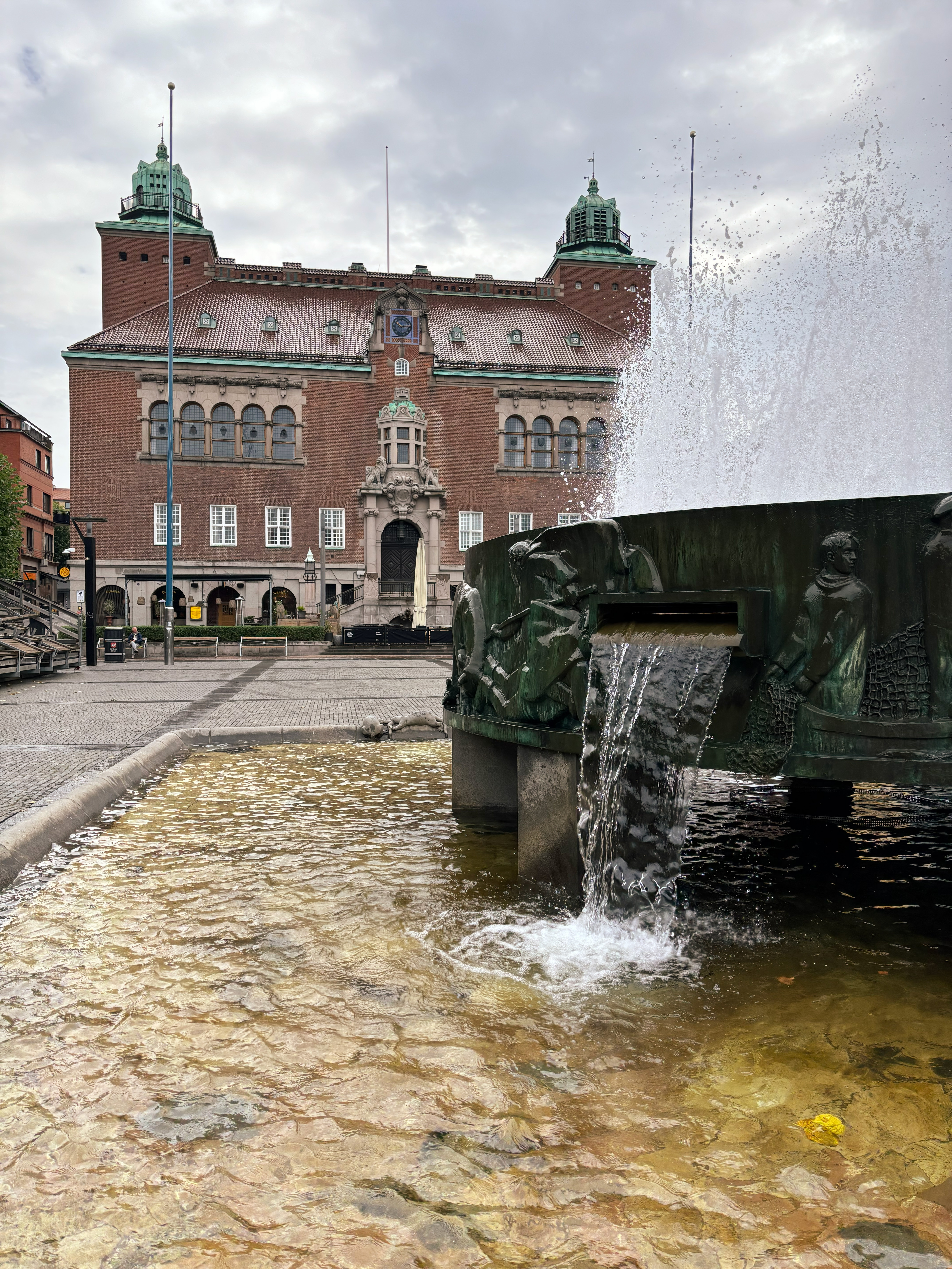 Torg med fontän i förgrunden.