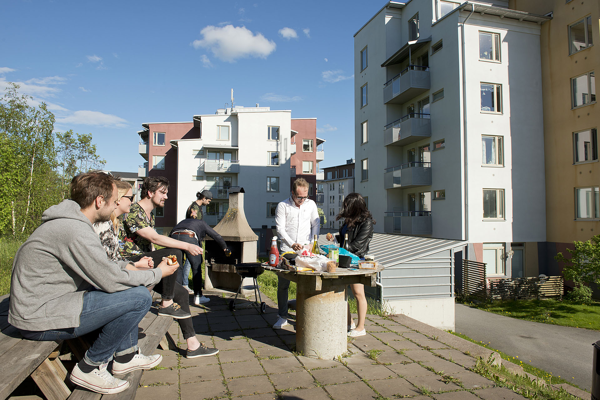 Sankta Katarina studentbostäder ligger när Örebro universitet. På bilden syns lägenhetshusen i bakgrunden, bakom studenter som grillar på den gemensamma grillplatsen. 