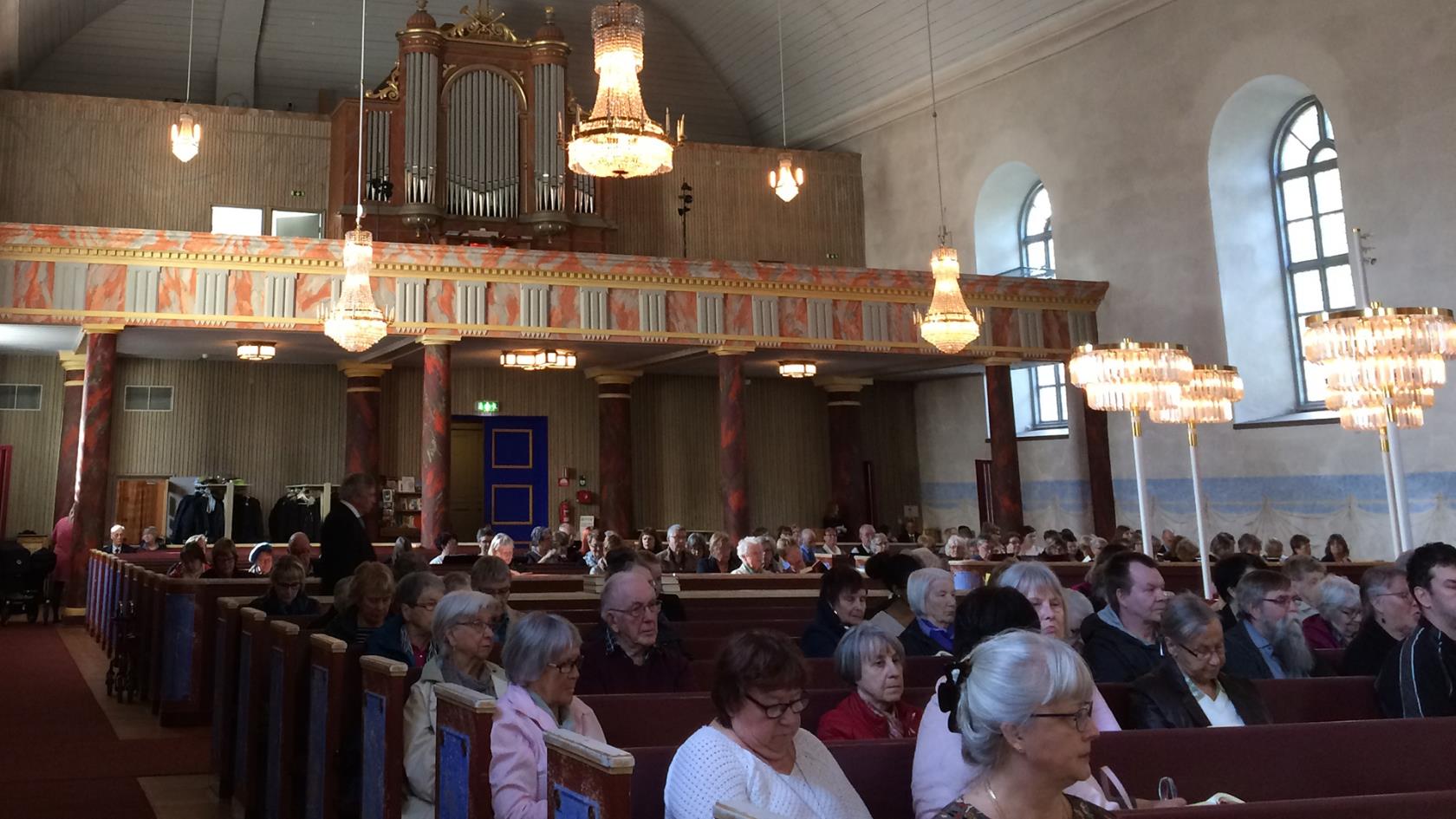 Besökare sittande i kyrkbänkarna under vårkonserten i Överluleå kyrka den 14 maj 2017
