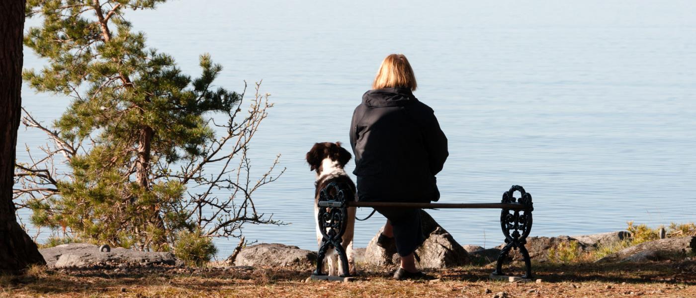 Kvinna på bänk vid havet