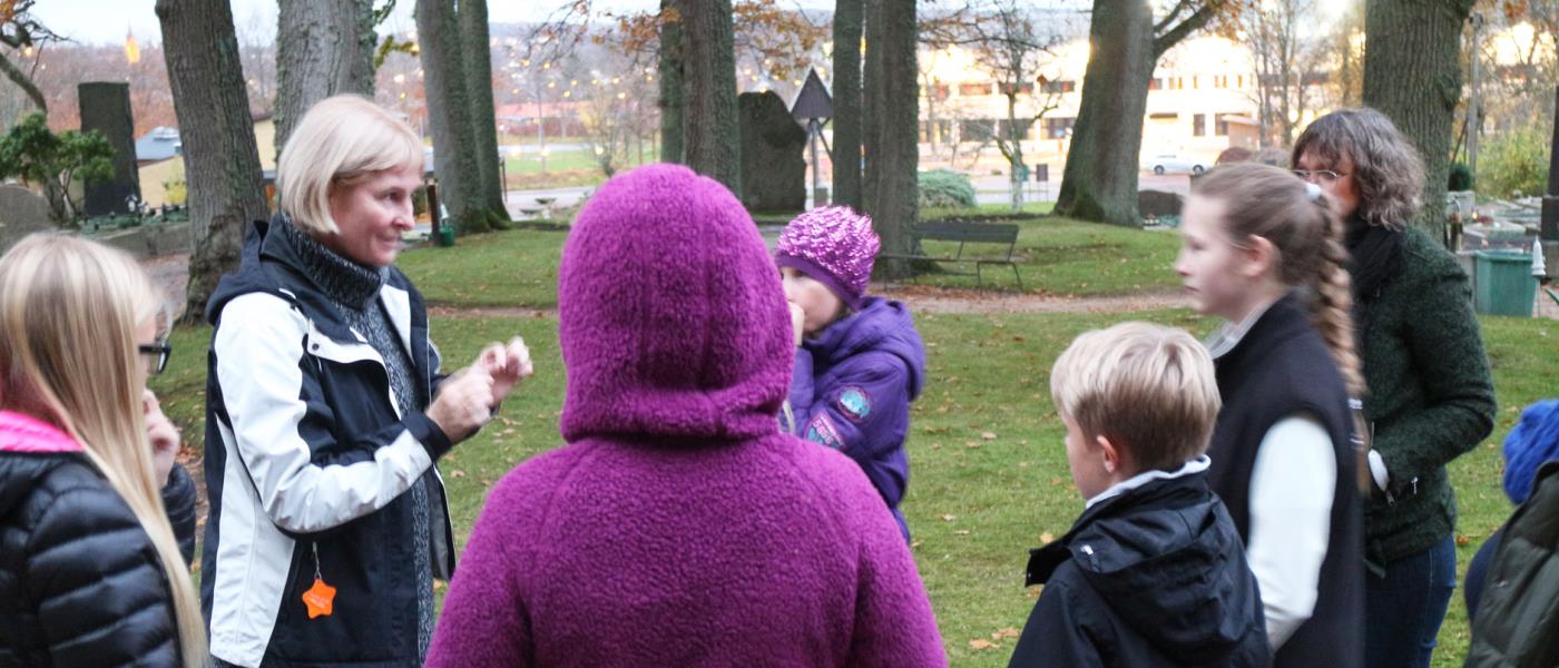 Skolbarnsgrupp på kyrkogårdsvandring