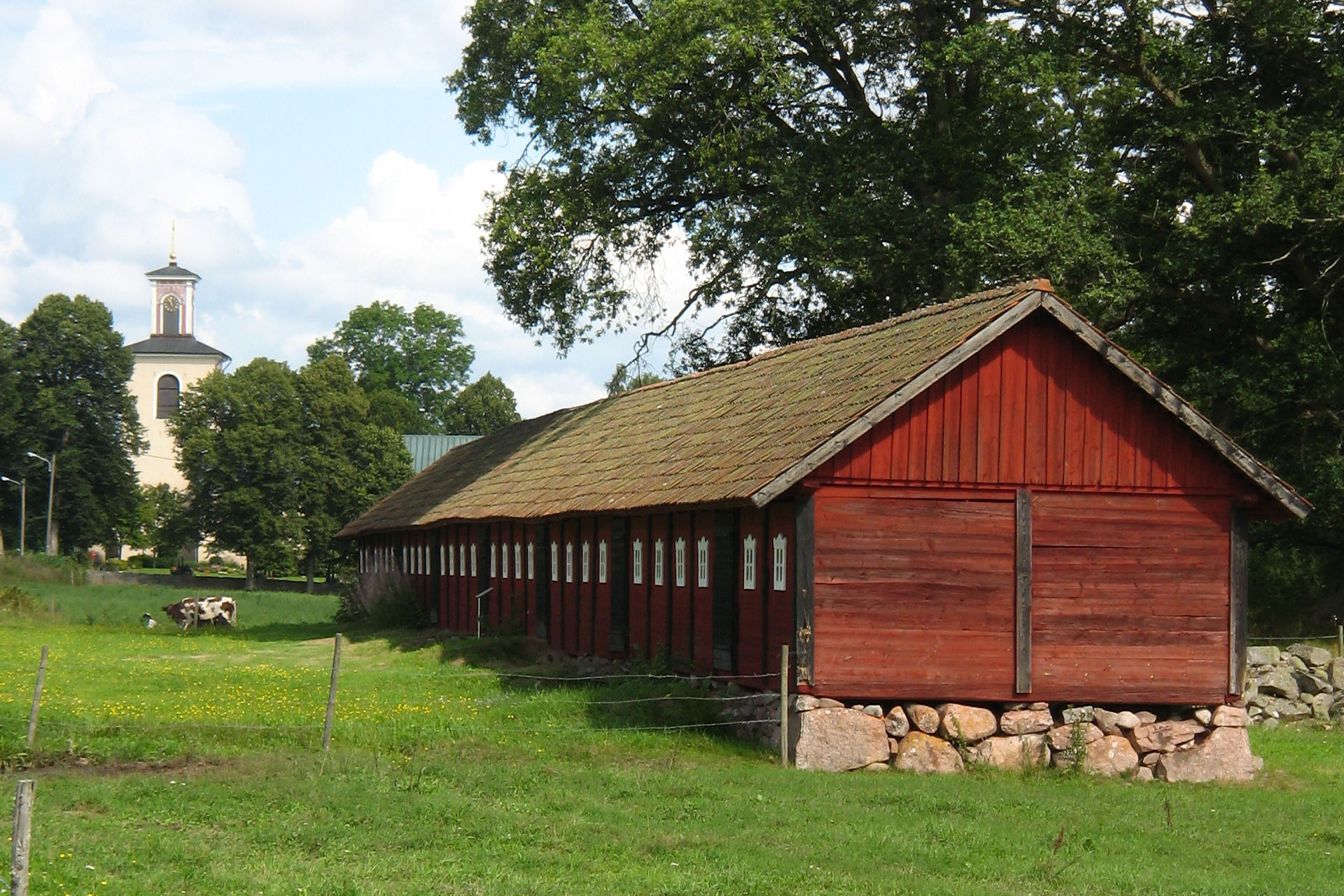 De gamla kyrkstallarna med Ljuders kyrka i bakgrunden
