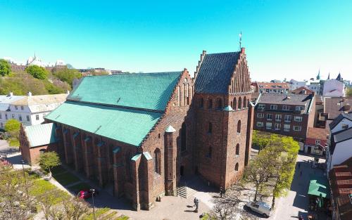 S:ta Maria kyrka i Helsingborg ses snett uppifrån. Det är en röd, medeltida tegelkyrka med koppartak.