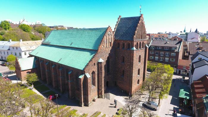 S:ta Maria kyrka i Helsingborg ses snett uppifrån. Det är en röd, medeltida tegelkyrka med koppartak.