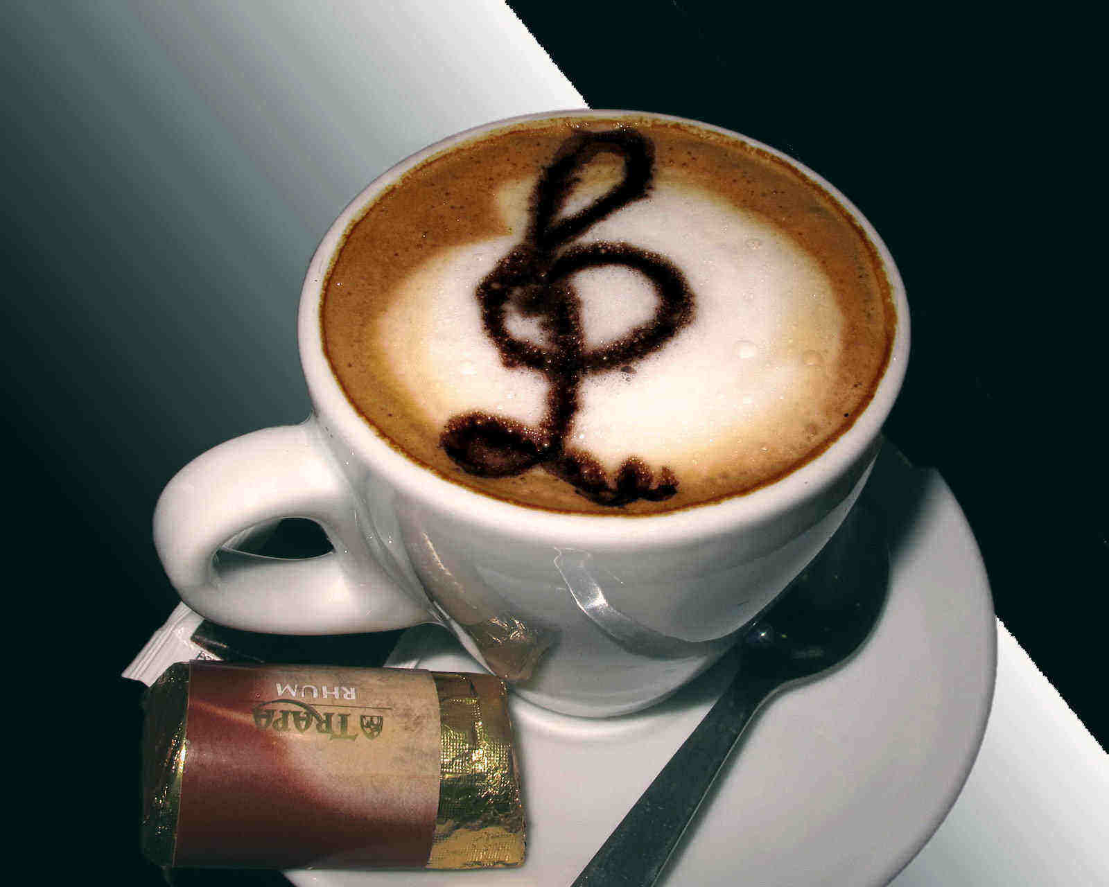 Kaffekopp med G-klav på skummad mjölk.