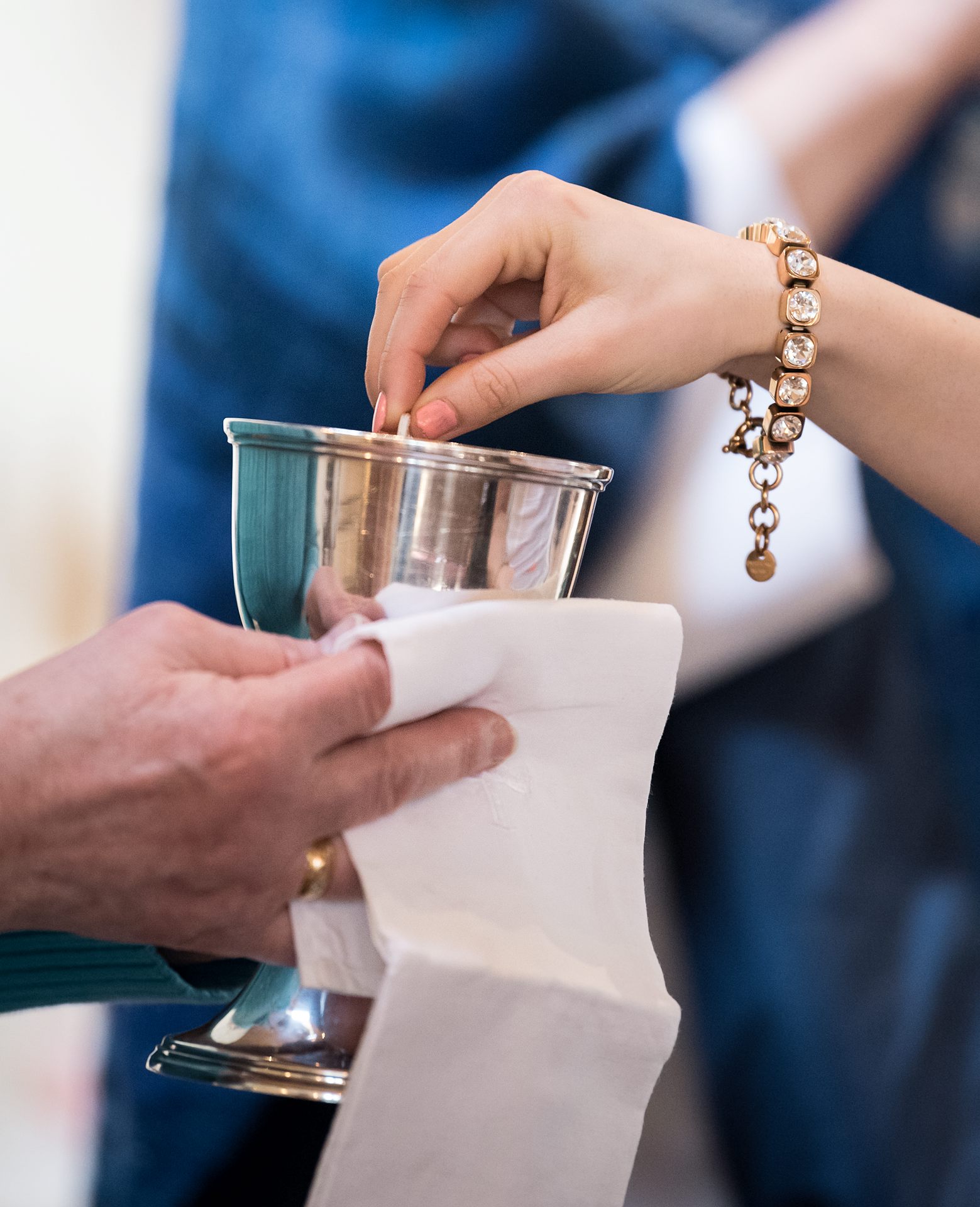 Hand som adoppar oblaten i kalken