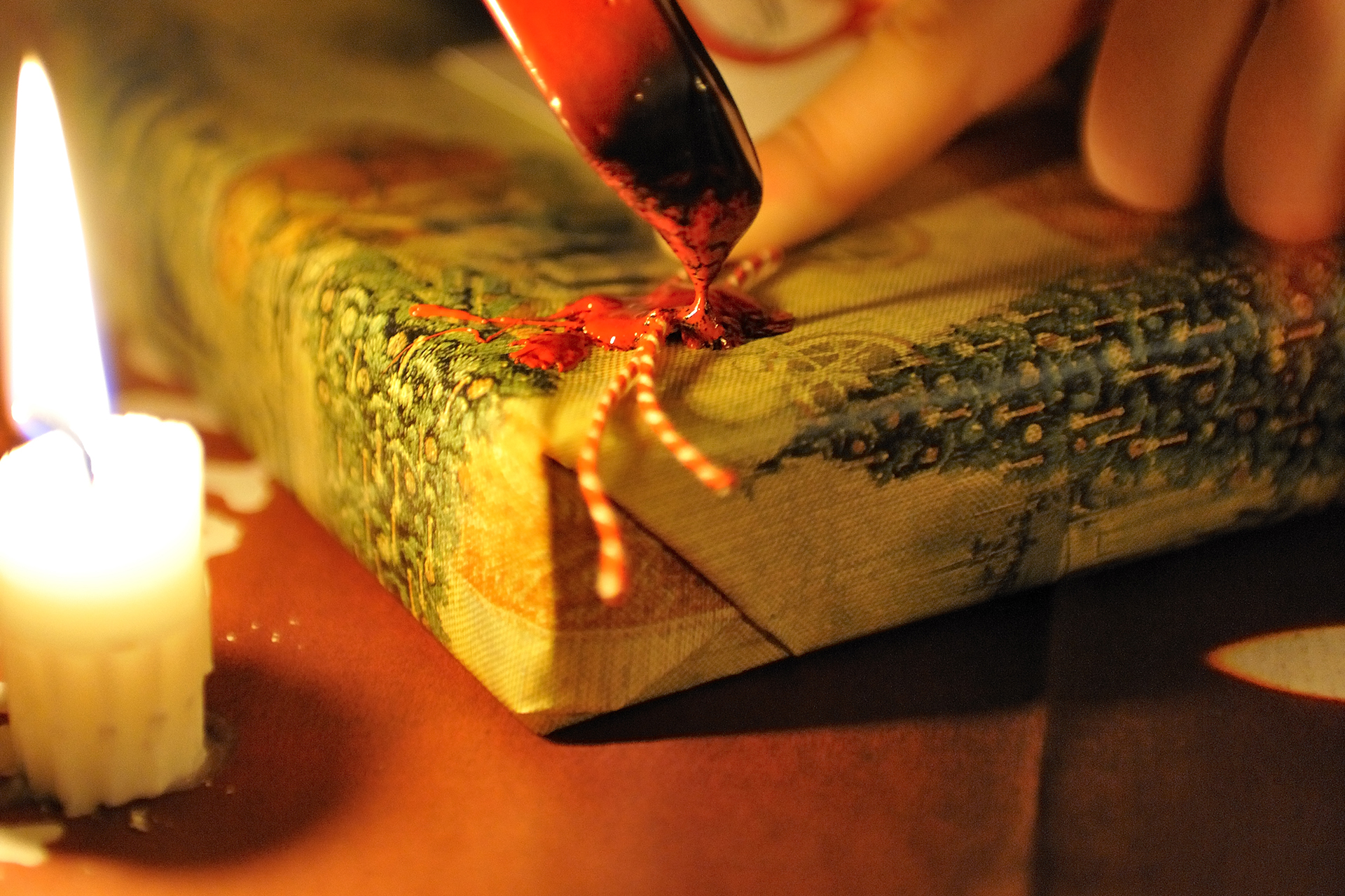 Någon slår in en julklapp i presentpapper.