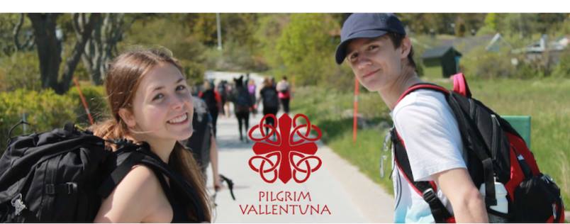 Människor vandrar på en väg, två ungdomar i förgrunden. 