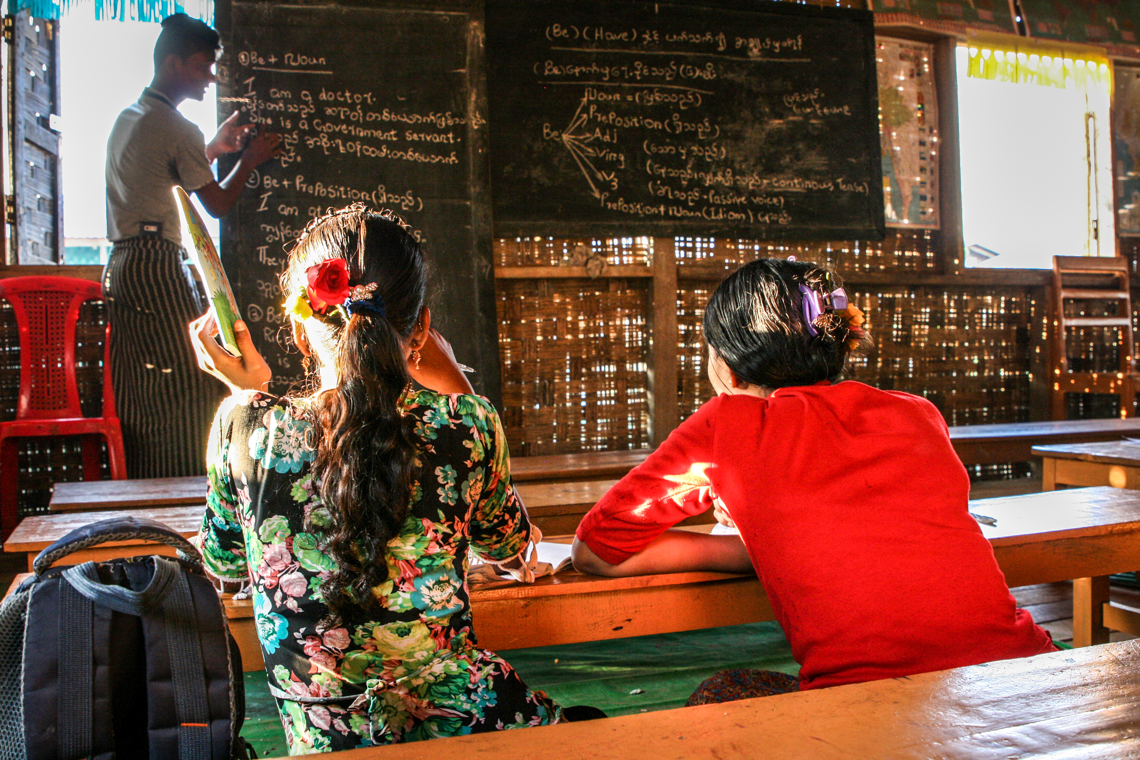 Två flickor undervisas i ett klassrum.