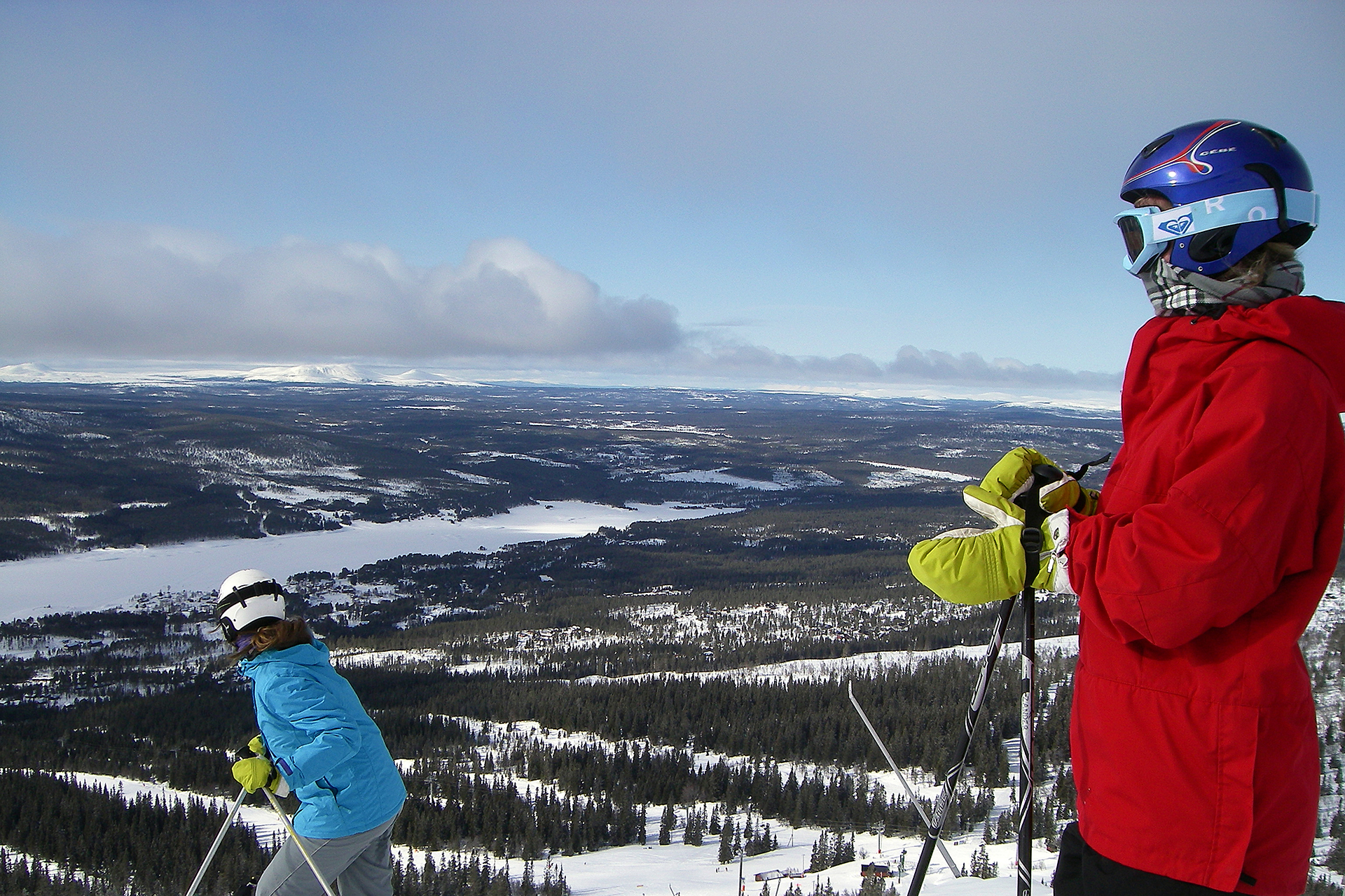 Två slalomåkare som blickar ut över fjällen.