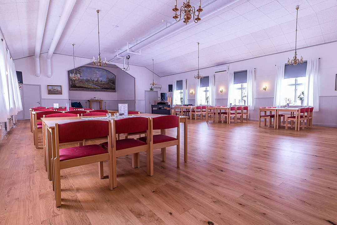 Vy över stora salen i Fröjereds församlingshem/lägergård. Bild tagen mot scenen.