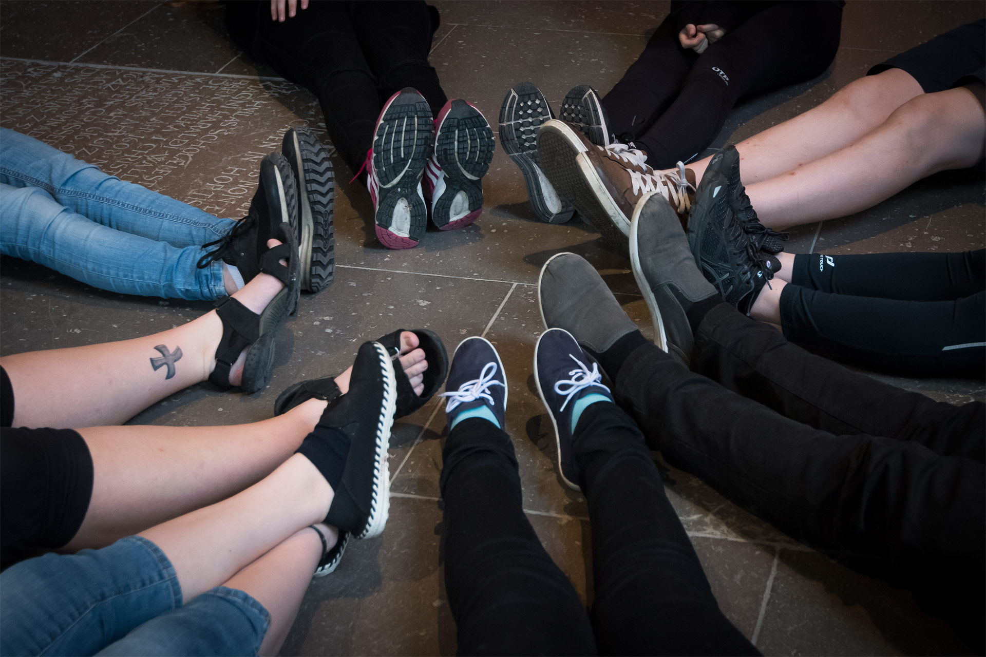 ungdomar sitter i ring med fötterna mot varandra