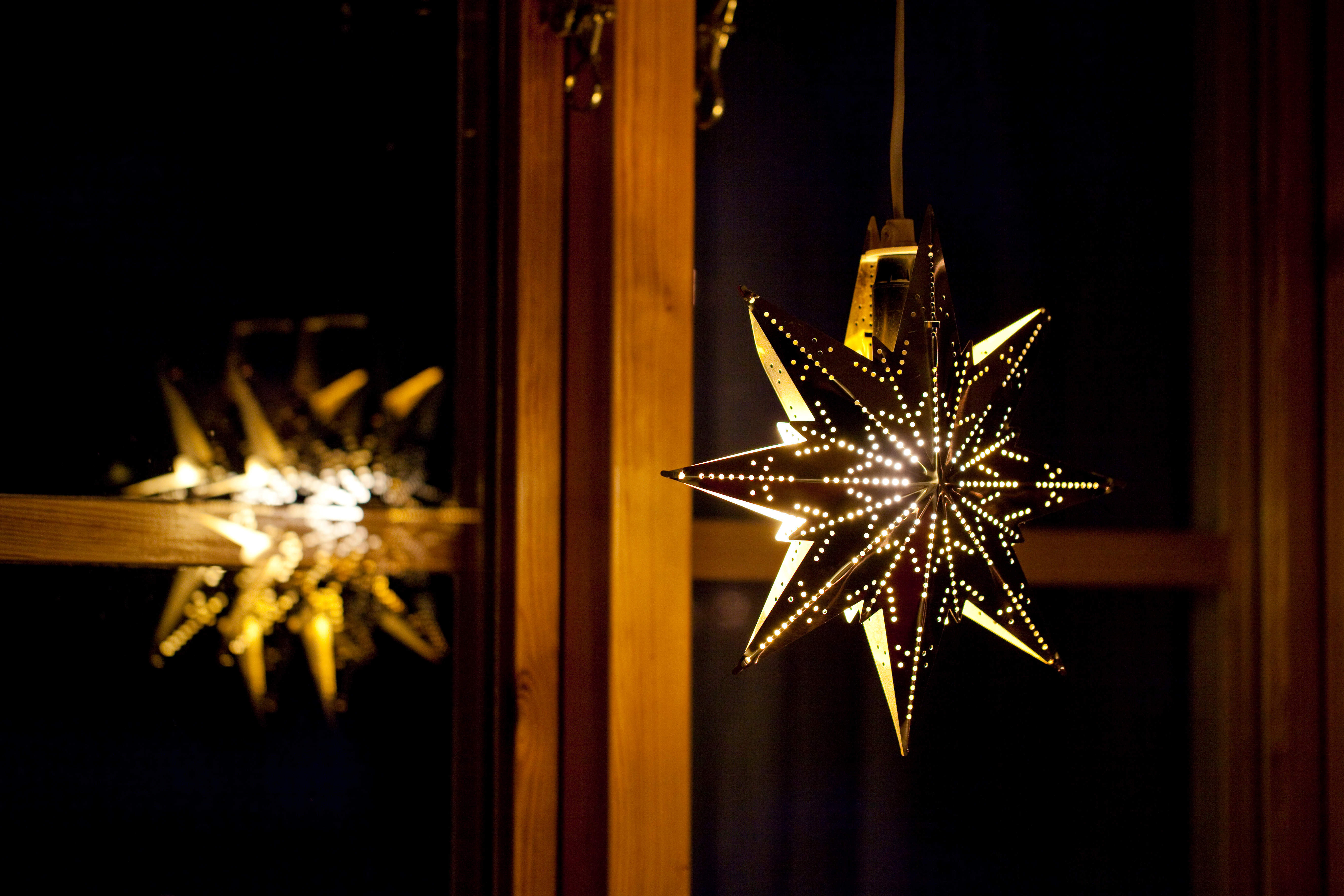 En adventsstjärna lyser i ett fönster.