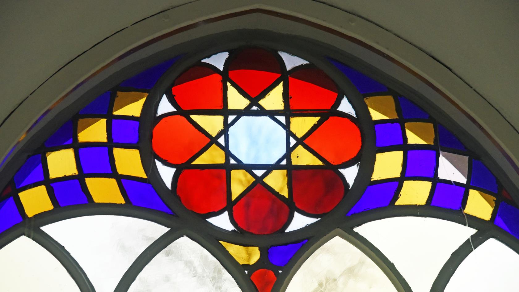 Detalj av ett färggrant kyrkfönster.