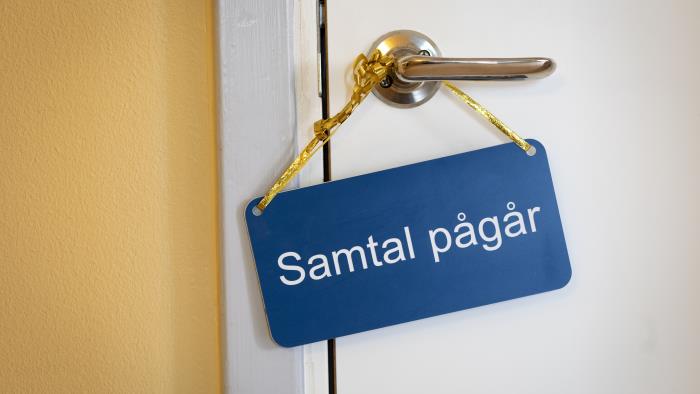 På ett handtag hänger en skylt med texten Samtal pågår.